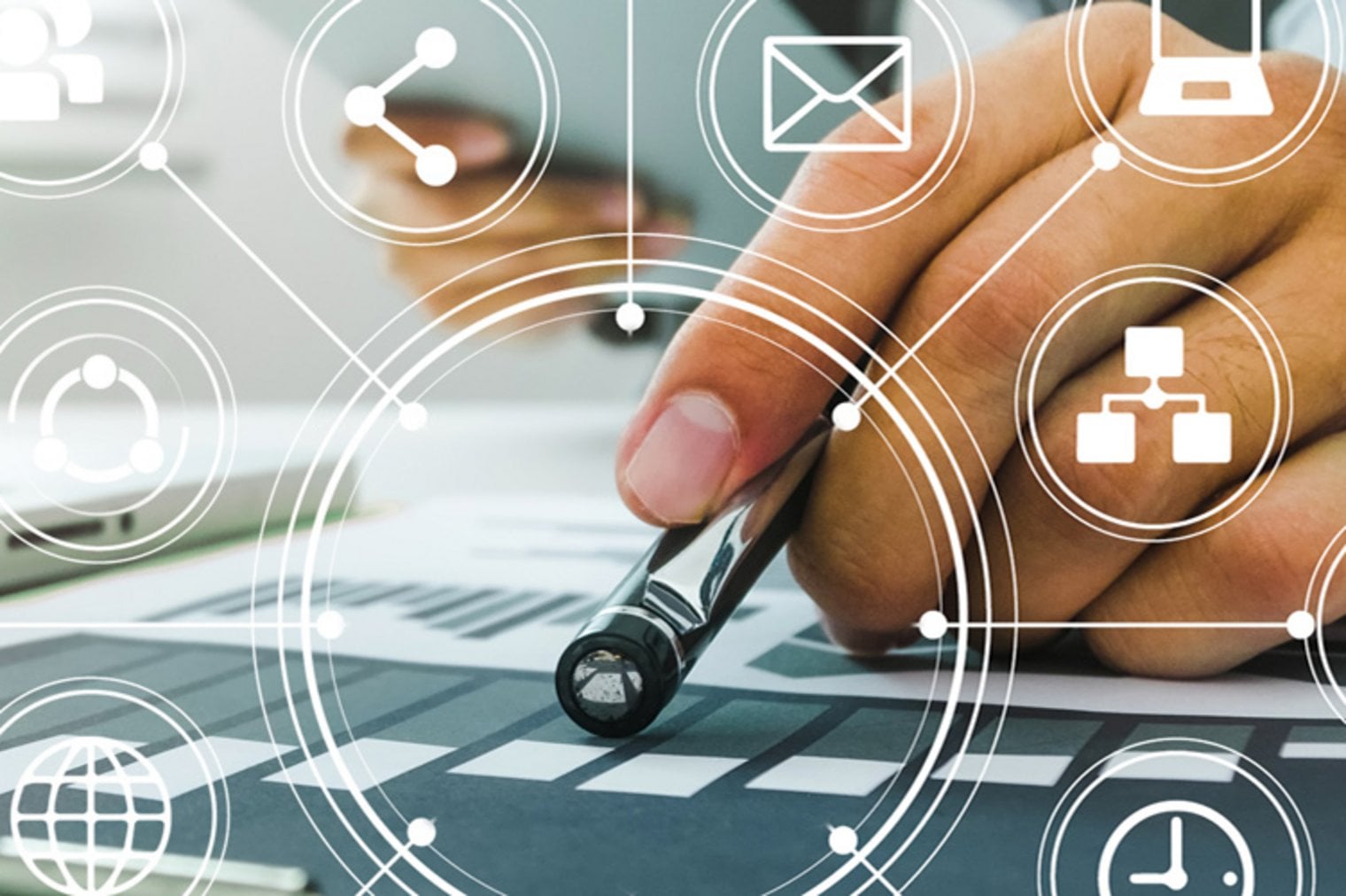 Nahaufnahme einer Hand, die mit einem Stift auf ein Diagramm zeigt. Im Vordergrund sind transparente weiße Icons wie Briefumschlagen, Vernetzungssymbol u. a. aus dem IT-Bereich zu sehen 